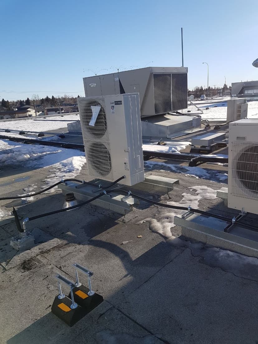 Mitsubishi City Multi VRF commercial rooftop unit with snow cover showing cold-climate heat pump operation